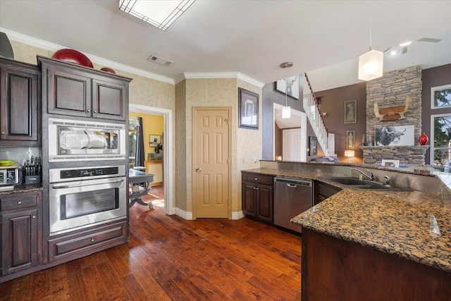 kitchen with sink, pendant lighting, dark brown cabinetry, and stainless steel appliances