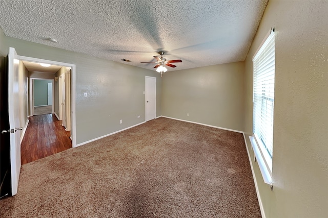 carpeted empty room featuring ceiling fan and a textured ceiling