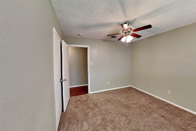 spare room featuring carpet floors, a textured ceiling, and ceiling fan