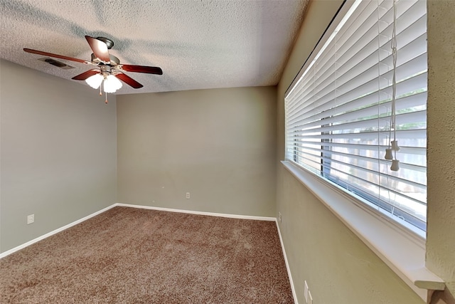 spare room featuring ceiling fan, carpet flooring, and a textured ceiling