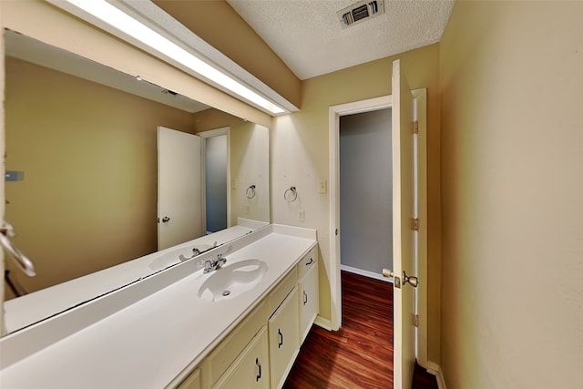 bathroom featuring hardwood / wood-style flooring, a textured ceiling, and vanity