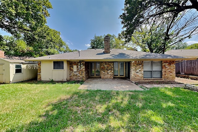 back of property featuring a storage shed, a lawn, and a patio