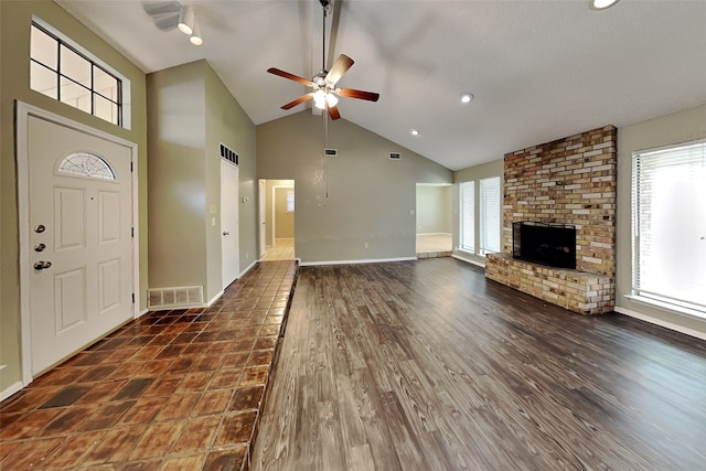 unfurnished living room featuring a fireplace, a healthy amount of sunlight, dark hardwood / wood-style floors, and ceiling fan