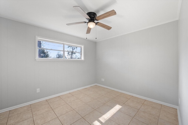 tiled spare room featuring ceiling fan and ornamental molding