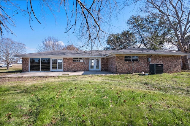 back of house with central air condition unit, a patio area, and a yard