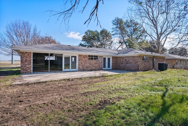 back of property with french doors, a patio area, central AC unit, and a lawn