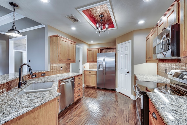 kitchen with sink, pendant lighting, dark hardwood / wood-style flooring, backsplash, and stainless steel appliances