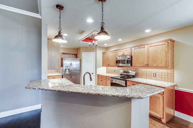 kitchen featuring decorative light fixtures, stainless steel appliances, decorative backsplash, hardwood / wood-style flooring, and light stone counters