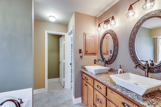 bathroom with vanity, a washtub, tile patterned floors, and a textured ceiling