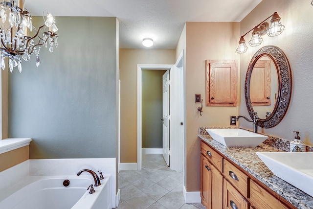 bathroom with a textured ceiling, a tub to relax in, tile patterned floors, and vanity