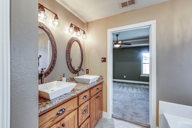 bathroom with a bathtub, tile patterned floors, ceiling fan, and vanity