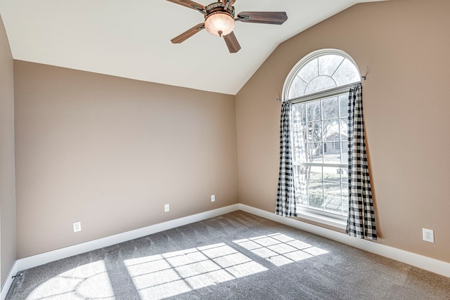 empty room with lofted ceiling, ceiling fan, and carpet