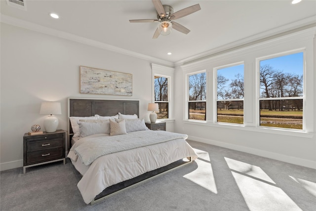 bedroom featuring multiple windows, crown molding, ceiling fan, and dark colored carpet