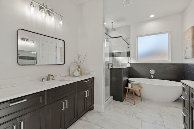 bathroom featuring vanity and separate shower and tub