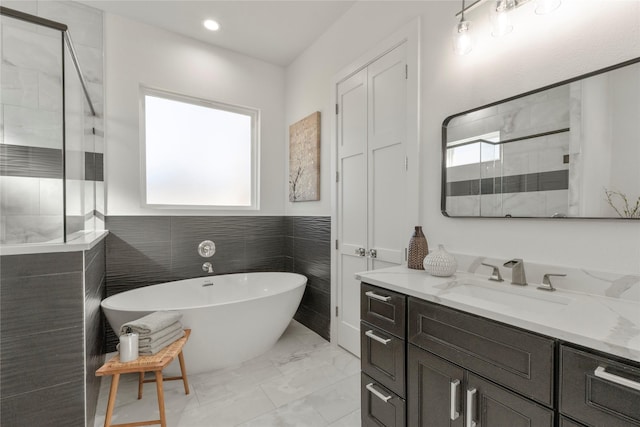 bathroom with vanity, separate shower and tub, and a wealth of natural light