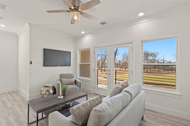 living room featuring ornamental molding, ceiling fan, and light hardwood / wood-style floors