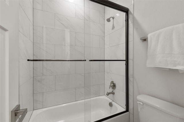 bathroom with bath / shower combo with glass door and toilet