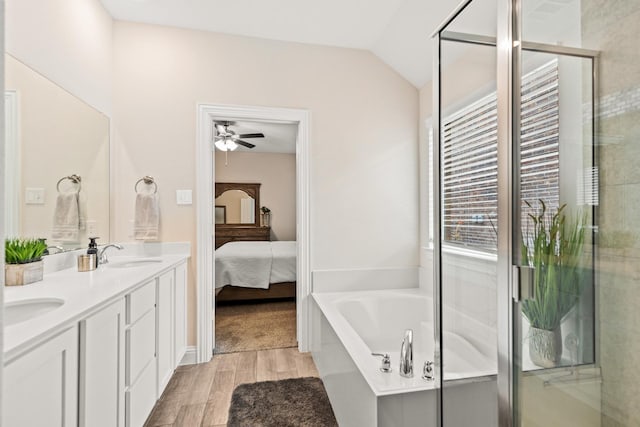 bathroom with ceiling fan, vanity, lofted ceiling, and plus walk in shower