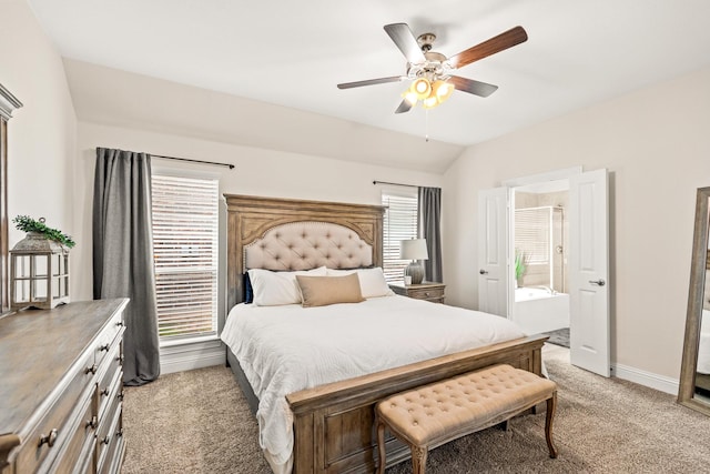 bedroom with ceiling fan, light colored carpet, connected bathroom, and multiple windows