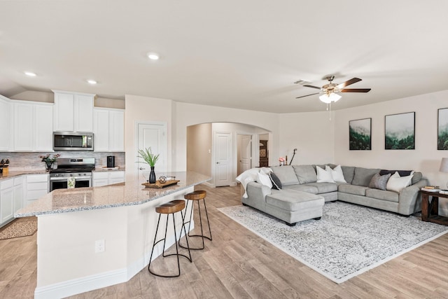 living room featuring ceiling fan and light hardwood / wood-style floors