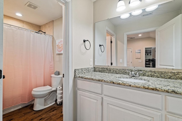 bathroom featuring vanity, hardwood / wood-style flooring, curtained shower, and toilet