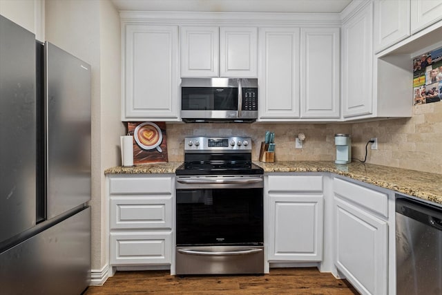 kitchen featuring backsplash, stainless steel appliances, light stone countertops, and white cabinets