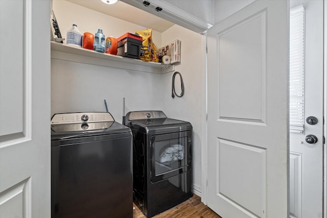 clothes washing area with hardwood / wood-style floors and washer and clothes dryer