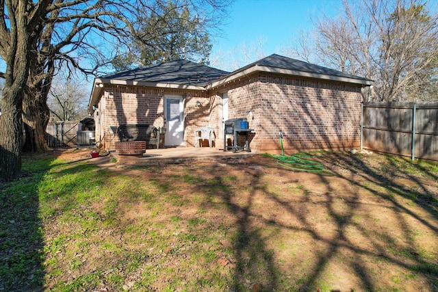 rear view of property with cooling unit, a lawn, and a patio