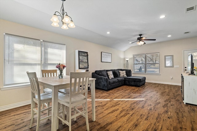 dining room featuring lofted ceiling, ceiling fan with notable chandelier, and dark wood-type flooring