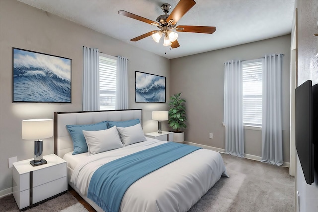 bedroom featuring light carpet, multiple windows, and ceiling fan