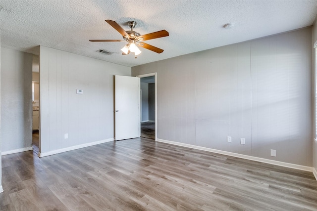 unfurnished room featuring ceiling fan, a textured ceiling, and light wood-type flooring