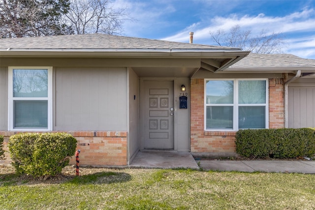 view of exterior entry with a lawn