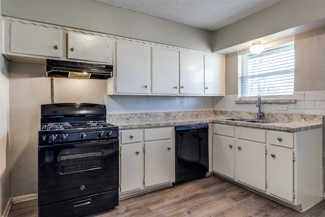 kitchen featuring sink, white cabinets, light hardwood / wood-style floors, a textured ceiling, and black appliances