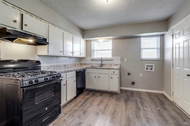 kitchen with sink, black appliances, white cabinets, and plenty of natural light