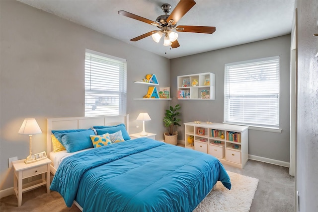 carpeted bedroom with ceiling fan and multiple windows