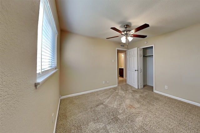 unfurnished bedroom featuring ceiling fan, a closet, and carpet flooring