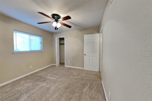 unfurnished bedroom with carpet, a textured ceiling, and ceiling fan