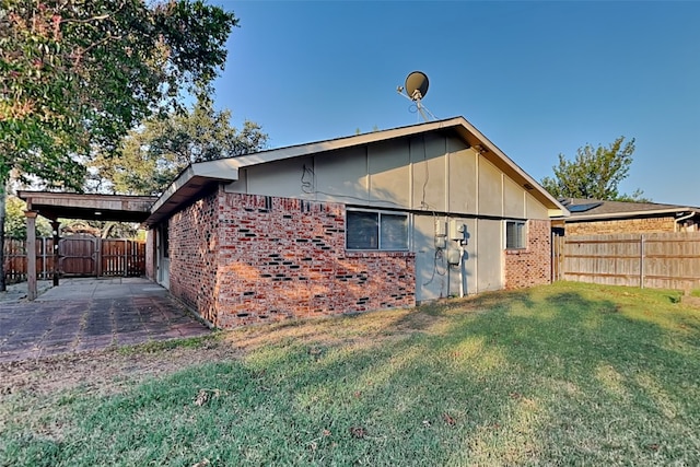 view of side of home featuring a patio and a lawn