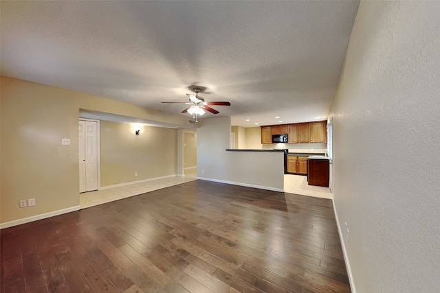 unfurnished living room featuring light wood-type flooring and ceiling fan