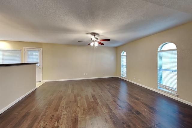 unfurnished room with ceiling fan, dark hardwood / wood-style floors, and a textured ceiling