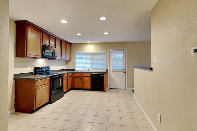 kitchen featuring black appliances, light tile patterned flooring, and sink