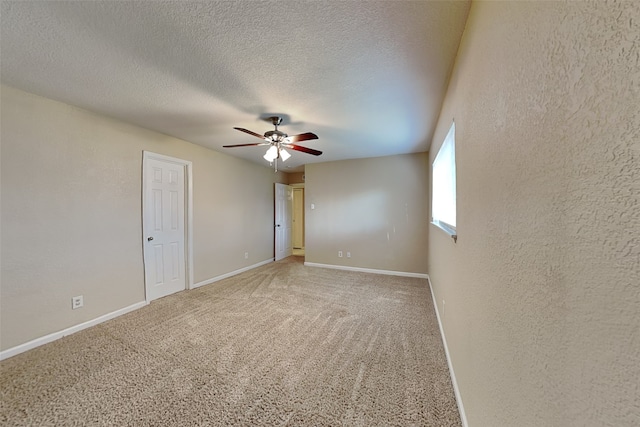 carpeted empty room with ceiling fan and a textured ceiling