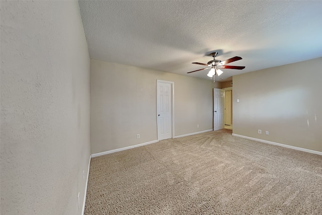 carpeted spare room with a textured ceiling and ceiling fan