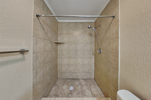 bathroom featuring crown molding, tiled shower, and toilet