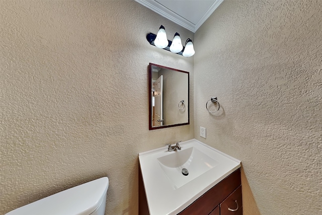 bathroom with vanity, toilet, and ornamental molding