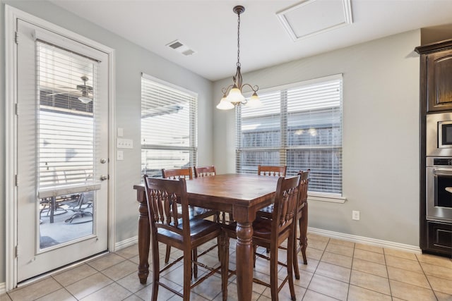 tiled dining room with a notable chandelier