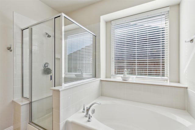 bathroom with independent shower and bath and a wealth of natural light