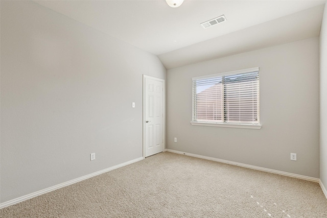 unfurnished room with carpet flooring and vaulted ceiling