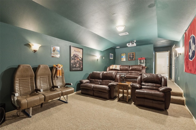 carpeted home theater room with lofted ceiling and a textured ceiling