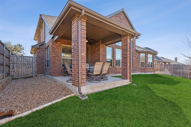 back of property featuring a lawn, a patio, and ceiling fan